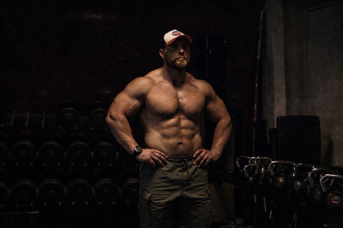 Josef Eriksson i gymmet, med hantlar och kettlebells bakom sig